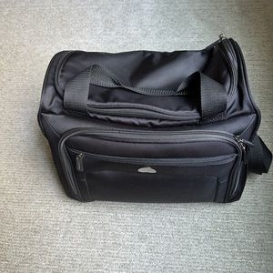 Unisex travel bag. Carried as tote, crossbody or strap over luggage handle.
